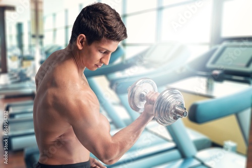 Young sporty man workout training biceps with dumbbell