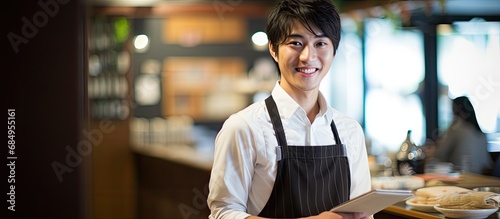 Fotografija In a quaint Japanese cafe, a young man with a charming smile works as a model em