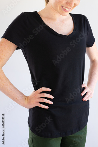 Vertical image of smiling caucasian woman in black t-shirt and copy space on white background