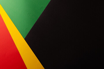 Green, yellow and red papers with copy space on black background