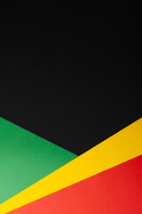 Vertical image of green, yellow and red papers with copy space on black background