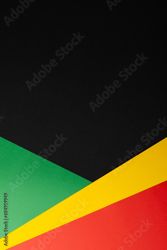 Vertical image of green, yellow and red papers with copy space on black background