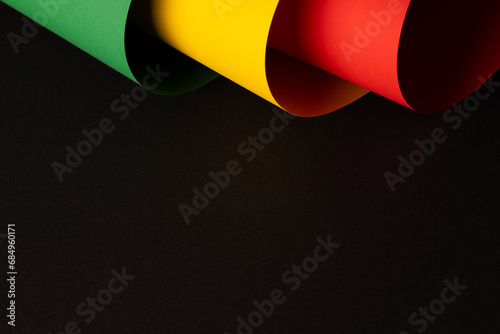 Green, yellow and red papers with copy space on black background