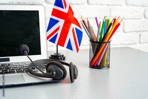 Laptop and flag of UK on desk. English language learning concept