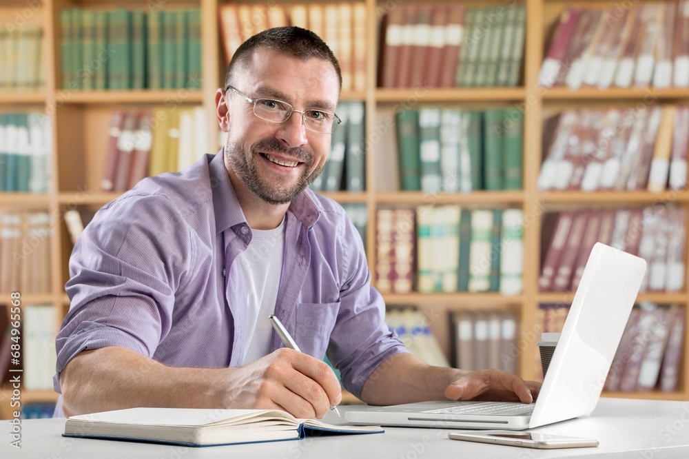 Young college student studying at library for research Young college student studying at library for research