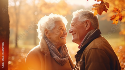 秋冬の自然の中で、高齢者の老夫婦2人が笑顔で向かい合って笑って微笑んでいる写真 photo