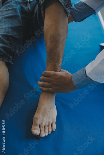 Doctor or physical therapist examines back pain and spinal area to give advice within the rehabilitation center.