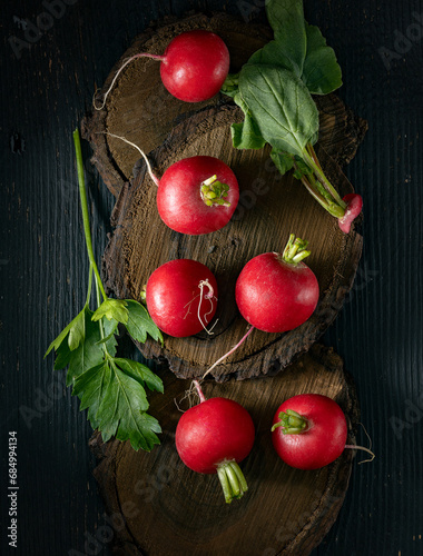 Red radishes on black background top view