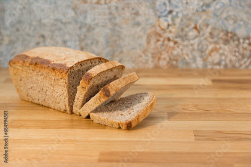 freshly baked homemade bread cut into thick slices on a wooden kitchen counter photo