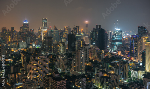 Night urban Bangkok cityscape skyline panorama of modern illuminated city with glowing skyscrapers and buildings in dusk. High-angle view on metropolis lights in twilight