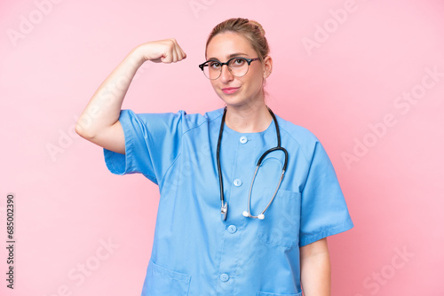 Young surgeon nurse woman isolated on pink background doing strong gesture