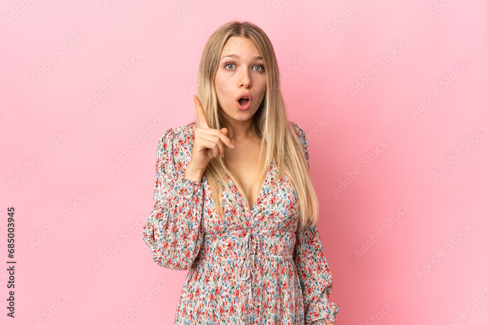 Young blonde woman isolated on pink background intending to realizes the solution while lifting a finger up Young blonde woman isolated on pink background intending to realizes the solution while lifting a finger up