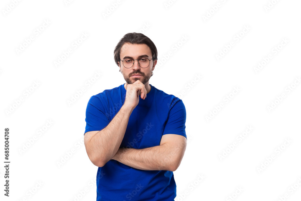 young smart brunette man with a beard dressed in a blue t-shirt is brainstorming on a white background young smart brunette man with a beard dressed in a blue t-shirt is brainstorming on a white background