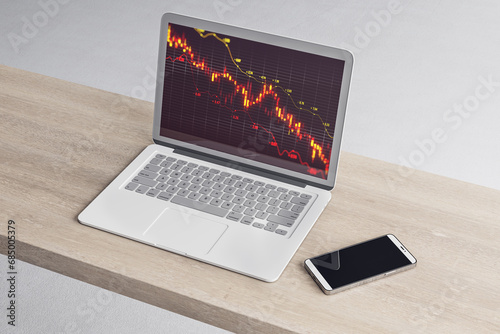 Close up of laptop and cellphone on wooden desk with downward red candlestick forex chart with grid and index on blurry background. Crisis, falling stock market and recession concept. 3D Rendering.