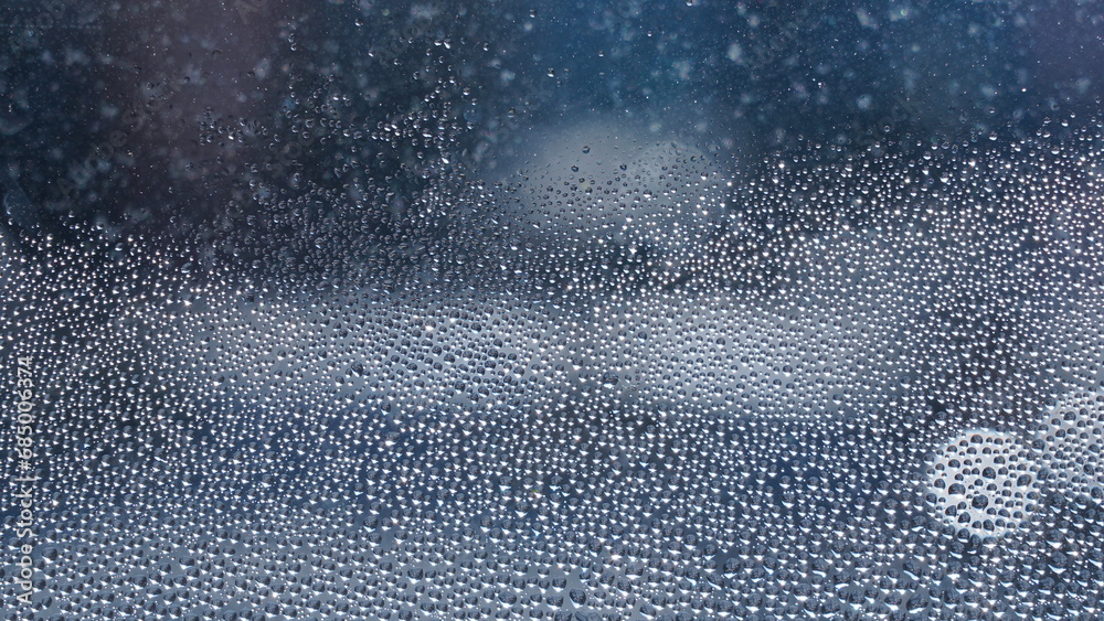 Obraz premium Condensation on window glass in frosty winter weather. Background in the form of small drops on the glass.