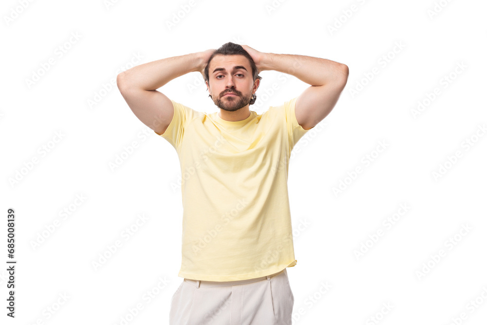 stylish young brunette man in a yellow t-shirt on a white background with copy space stylish young brunette man in a yellow t-shirt on a white background with copy space