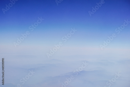 high clouds with dense fog and deep blue sky during a flight