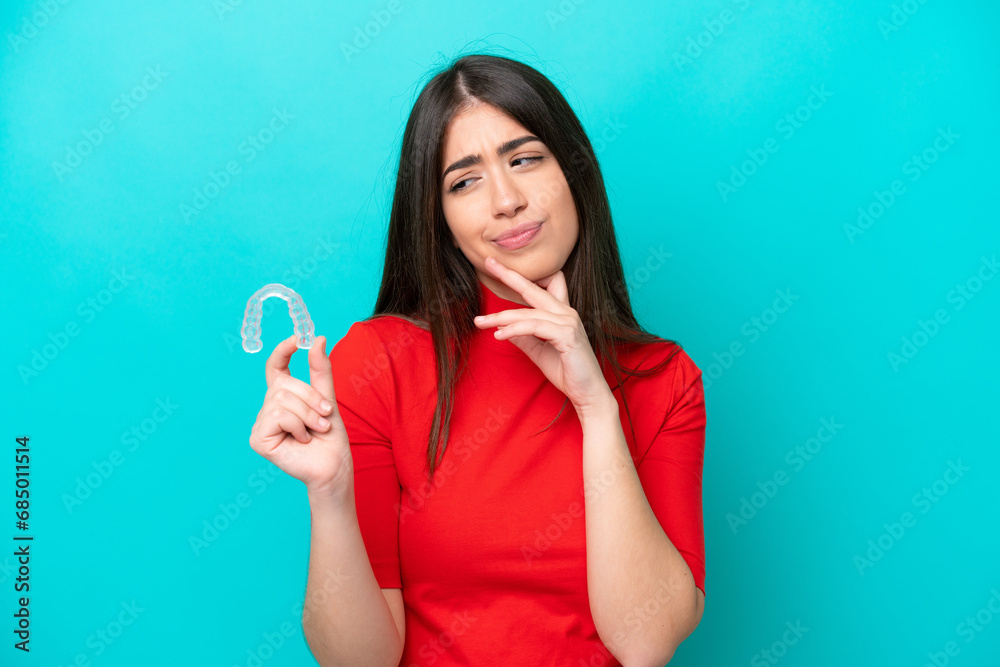 Young caucasian woman holding a envisaging isolated on blue background with sad expression Young caucasian woman holding a envisaging isolated on blue background with sad expression