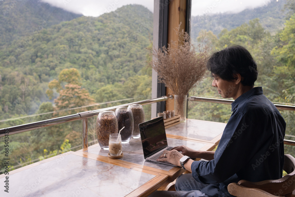 digital nomad concept asian freelancer man use laptop to work at mountain view of coffeeshop digital nomad concept asian freelancer man use laptop to work at mountain view of coffeeshop
