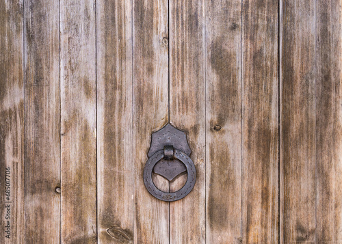 Part of a large wooden door with an iron handle and ring. Spain