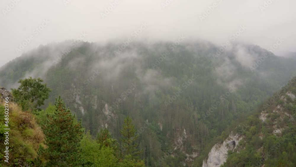 Low angle shot of mountain peak in clouds and fog in Zaovine, Serbia Low angle shot of mountain peak in clouds and fog in Zaovine, Serbia