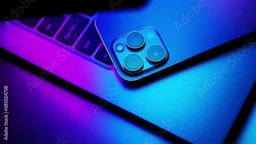 Close up of laptop and smartphone in neon light