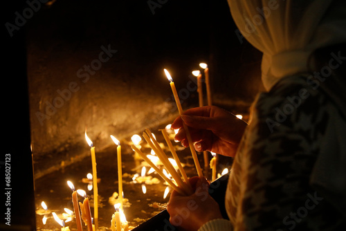 Faithful lighting candles in Transfiguration church, Chisinau, Moldova. © Julian