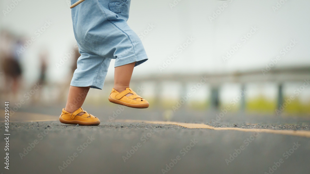 close up leg of infant baby learning to walking first step on pathway - obrazy, fototapety, plakaty 