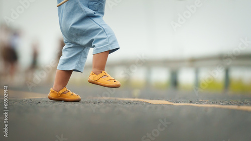 close up leg of infant baby learning to walking first step on pathway photo