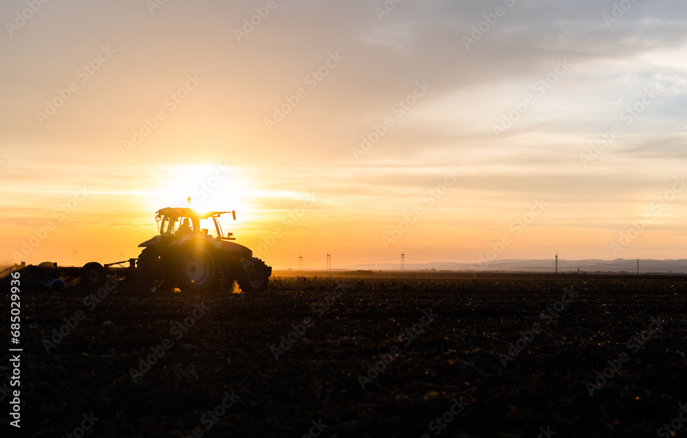 Fototapeta premium Farmer preparing his field in a tractor