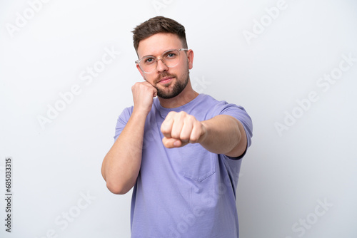 Young caucasian man isolated on white background with fighting gesture