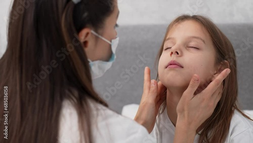 Pediatric doctor checking tonsils of a child girl photo