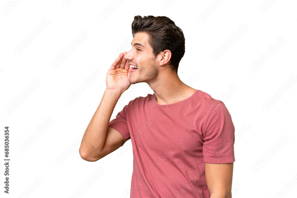 Young handsome caucasian man over isolated background shouting with mouth wide open to the lateral Young handsome caucasian man over isolated background shouting with mouth wide open to the lateral