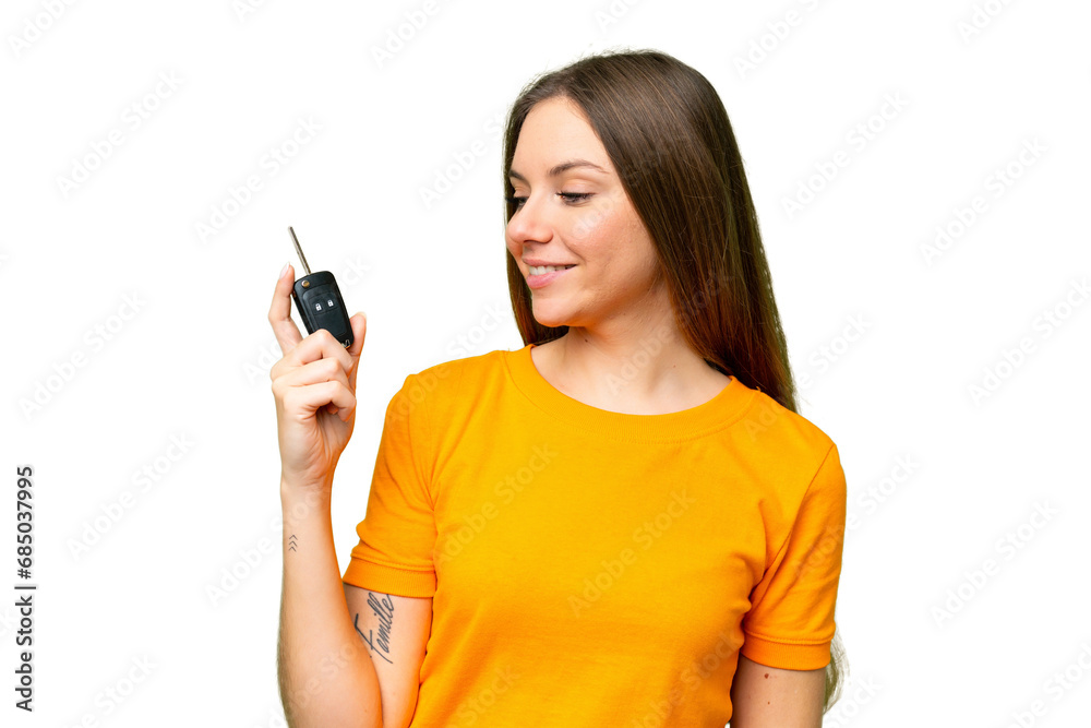 Young woman holding car keys over isolated chroma key background with happy expression