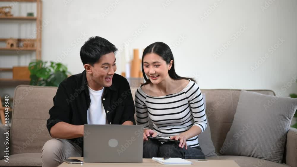 Two business workers talking on the smartphone and using laptop on sofa at home office. Two business workers talking on the smartphone and using laptop on sofa at home office.