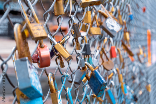Love locks on a railing. A close-up shot of love padlocks on a fence which signify everlasting love and commitment.