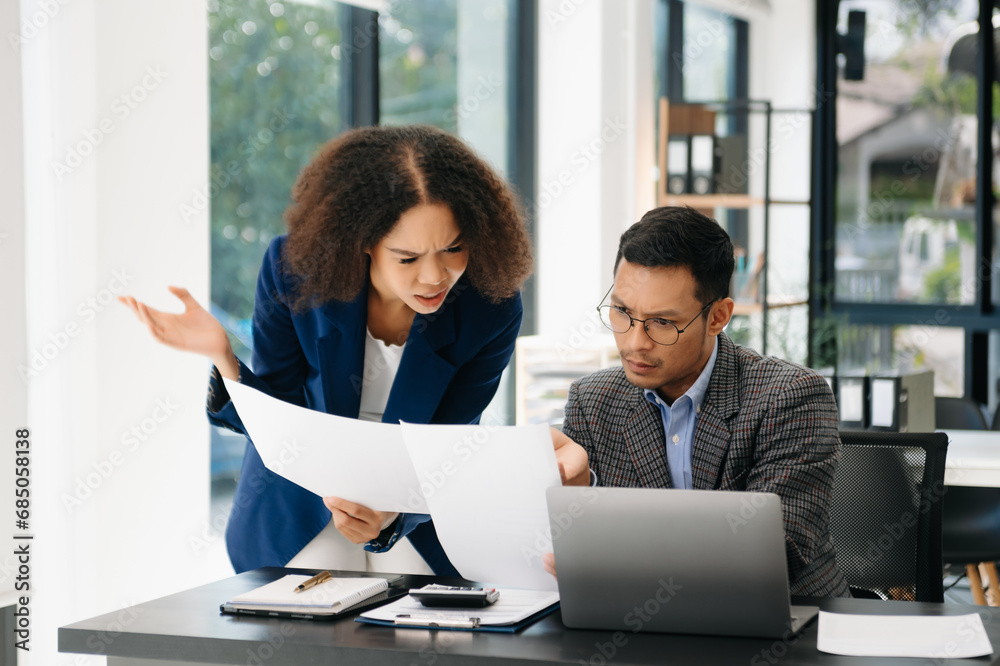 Furious two Asian businesspeople arguing strongly after making a mistake at work in office. Furious two Asian businesspeople arguing strongly after making a mistake at work in office.