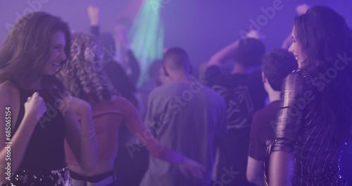 Women, friends dancing to music and nightclub for disco party, festival or celebration and excited for techno. Happy people in crowd and dance floor for rave, lights and social event in the club photo