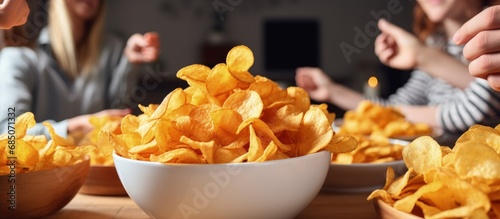 Friends enjoying potato chips at a houseparty in a closeup photo copy space image photo