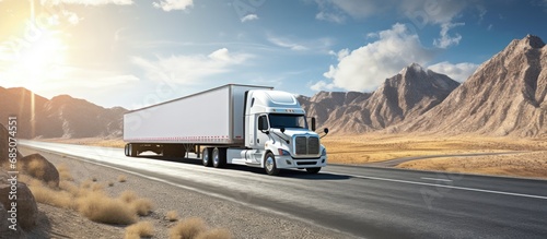 Large industrial truck hauling cargo in a dry van trailer on a wide straight highway with protective side barrier copy space image photo