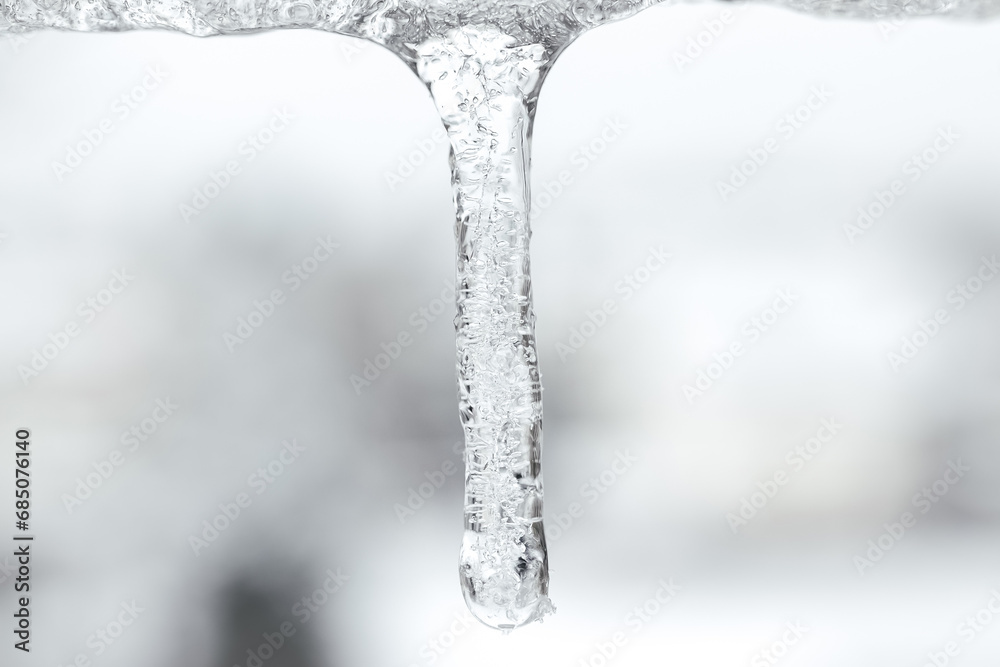 Icicle against light blue sky. Drop of melted snow falls down. Closeup. Illustration about end of winter or beginning of spring. Thaw. Macro. Icicle against light blue sky. Drop of melted snow falls down. Closeup. Illustration about end of winter or beginning of spring. Thaw. Macro.