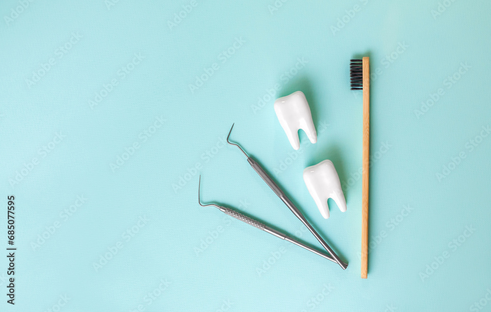 Dental model of tooth and dental equipment on blue background, concept image of dental background. Dental probe. Toothbrush. Dental health concept. Oral health examination and dental examination. Dental model of tooth and dental equipment on blue background, concept image of dental background. Dental probe. Toothbrush. Dental health concept. Oral health examination and dental examination.