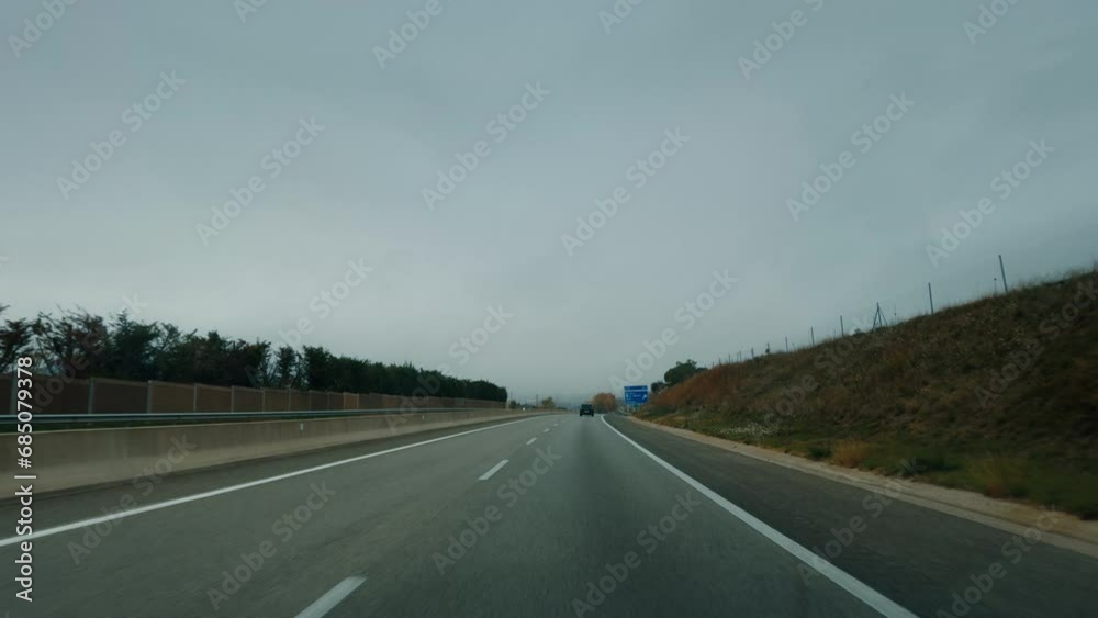 Wide shot driving on empty highway road on cloudy autumn day