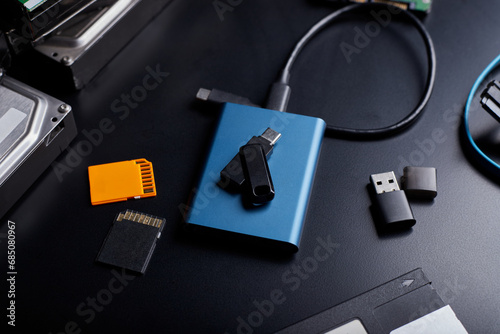 Close-up view of  SSD portable, USB thumb drive, SD card on black background.