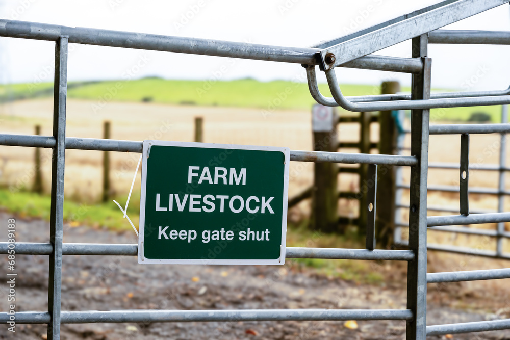 Farmers metal gate with a keep gate shut sign attached, displaying Farm Livestock, with agricultural fields in the background, located at Cardross, Argyll and Bute, Scotland, UK Farmers metal gate with a keep gate shut sign attached, displaying Farm Livestock, with agricultural fields in the background, located at Cardross, Argyll and Bute, Scotland, UK