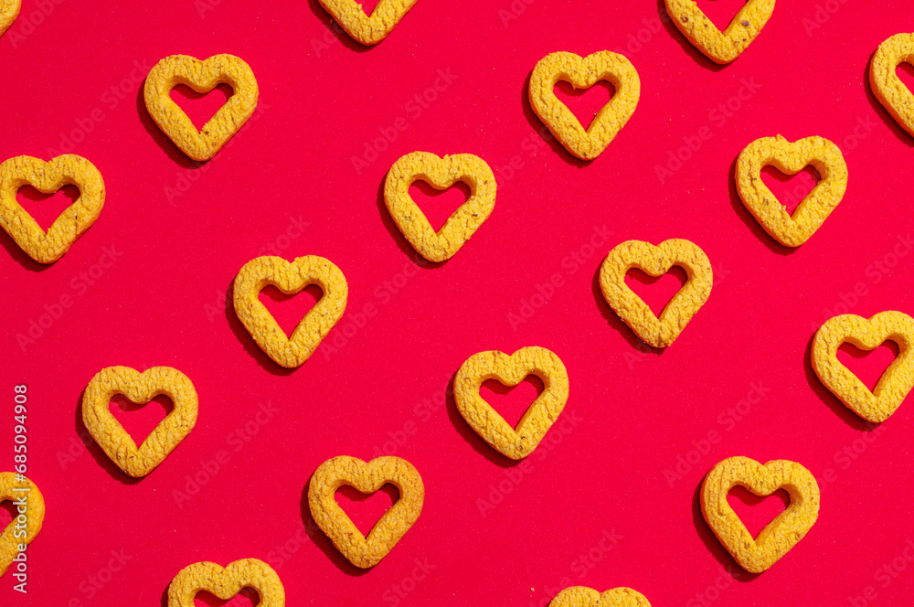 Fototapeta premium Small heart-shaped cookies on a red background.