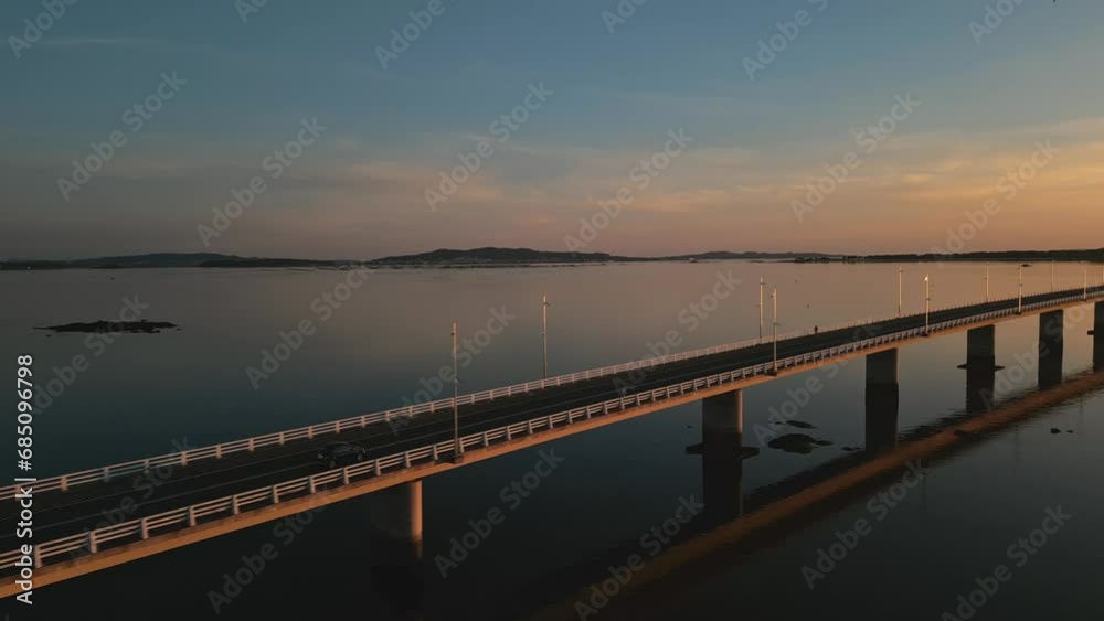 Establishing aerial view of a cars driving on a long sea bridge at sunset with a beautiful golden color reflect of the sea. Concept of transportation and travel in Spain Arosa Island Bridge Establishing aerial view of a cars driving on a long sea bridge at sunset with a beautiful golden color reflect of the sea. Concept of transportation and travel in Spain Arosa Island Bridge