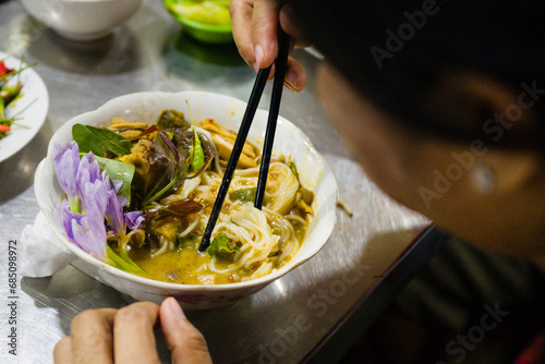 Woman eating noodles in the local orussey market in Phnom Penh