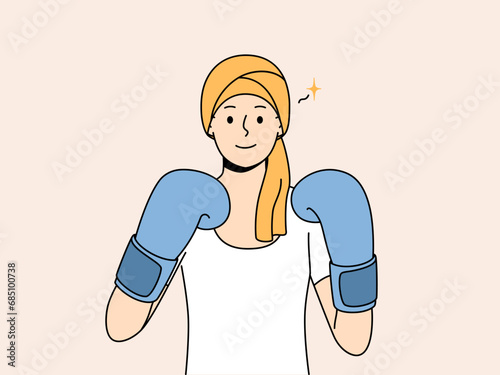 Woman with cancer in boxing gloves symbolizes fight against oncology after chemotherapy. Girl demonstrates desire to live and refuses to give up due to appearance of symptoms of cancer and hair loss