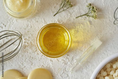 Essential ois, beeswax pellets, shea butter and other ingredients for homemade cosmetics photo